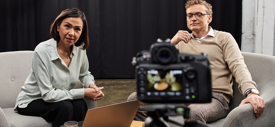 Grabación de entrevista corporativa: dos ejecutivos en sofá frente a cámara.