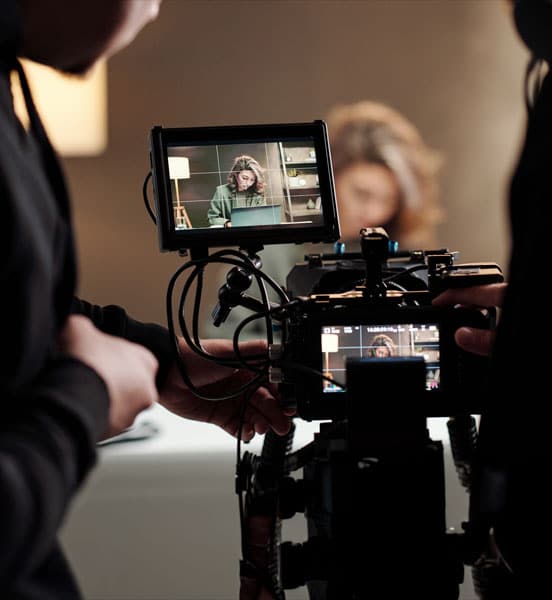 Grabación de entrevista para capacitación empresarial; cámara y monitor en primer plano.