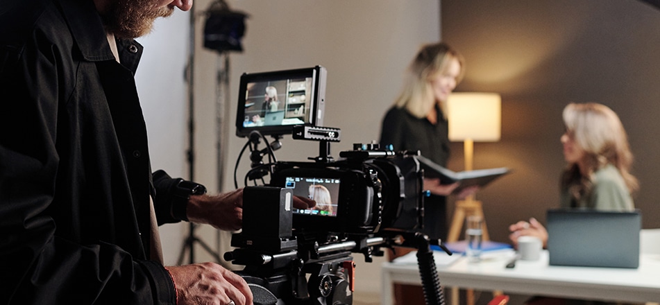 Grabación de entrevista corporativa: dos ejecutivos en sofá frente a cámara.